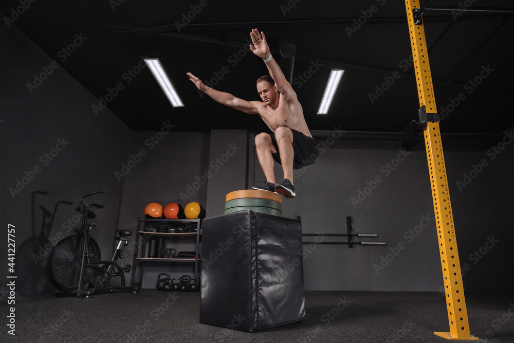Crossfit athlete doing box jump exercise as part of functional circuit
