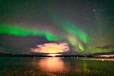 Nordlichter über dem Fjord in Troms bei Tromsö. Aurora Borealis in the sky, heavenly light in the dark night. the lady dance in the sky. Polarlicht, Nordlicht in Norwegen