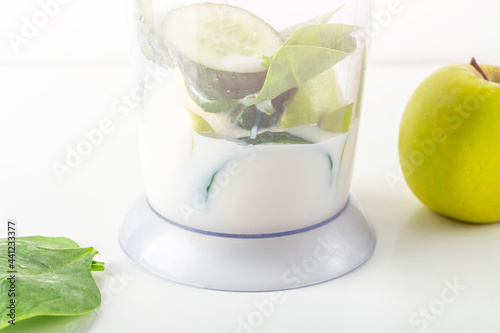 Step by step green smoothie recipe. Step 1 add soy milk to blender with apple, cucumber, spinach. Home cooking. Vegan healthy detox eating, dietary and weght loss drink