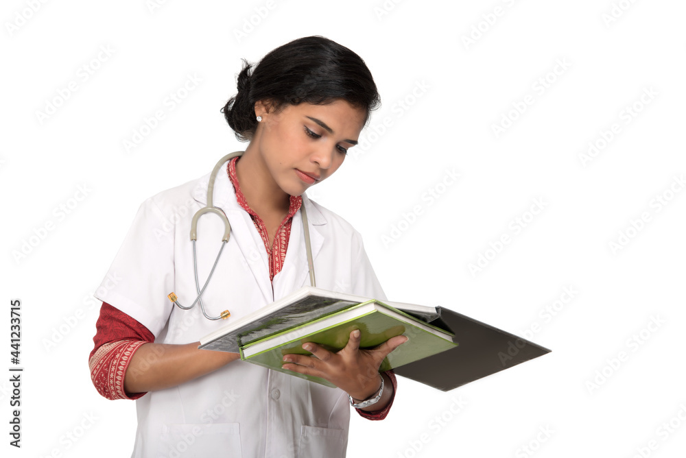 Young woman doctor with stethoscope is writing in book Young woman doctor with stethoscope is writing in book