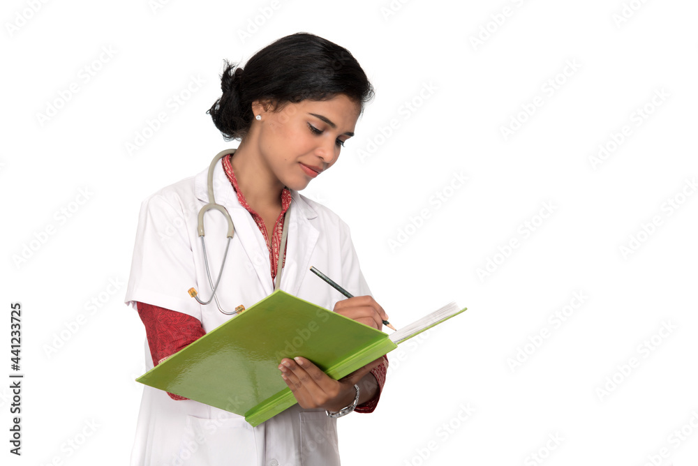 Young woman doctor with stethoscope is writing in book Young woman doctor with stethoscope is writing in book