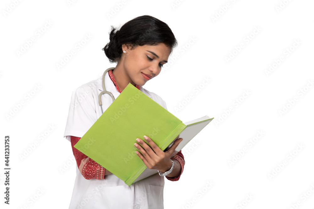 Young woman doctor with stethoscope is writing in book Young woman doctor with stethoscope is writing in book