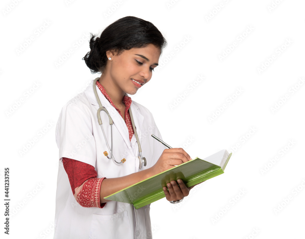 Young woman doctor with stethoscope is writing in book Young woman doctor with stethoscope is writing in book