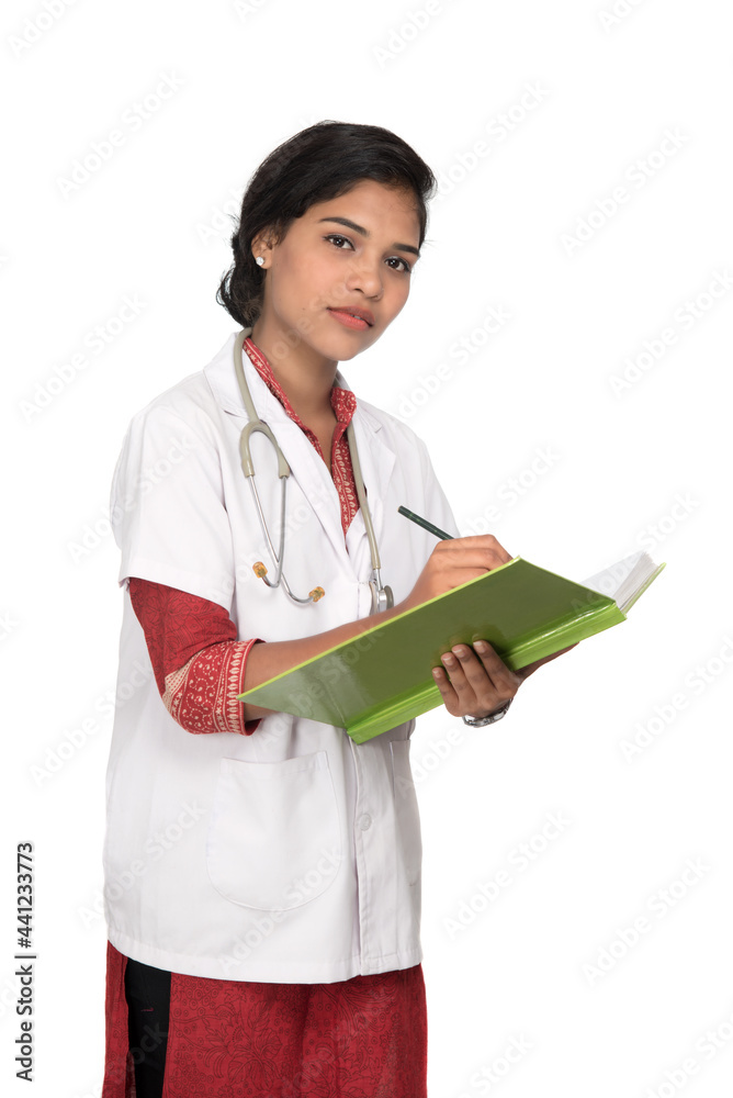 Young woman doctor with stethoscope is writing in book Young woman doctor with stethoscope is writing in book
