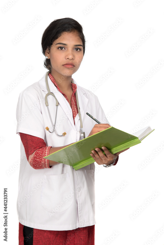 Young woman doctor with stethoscope is writing in book Young woman doctor with stethoscope is writing in book