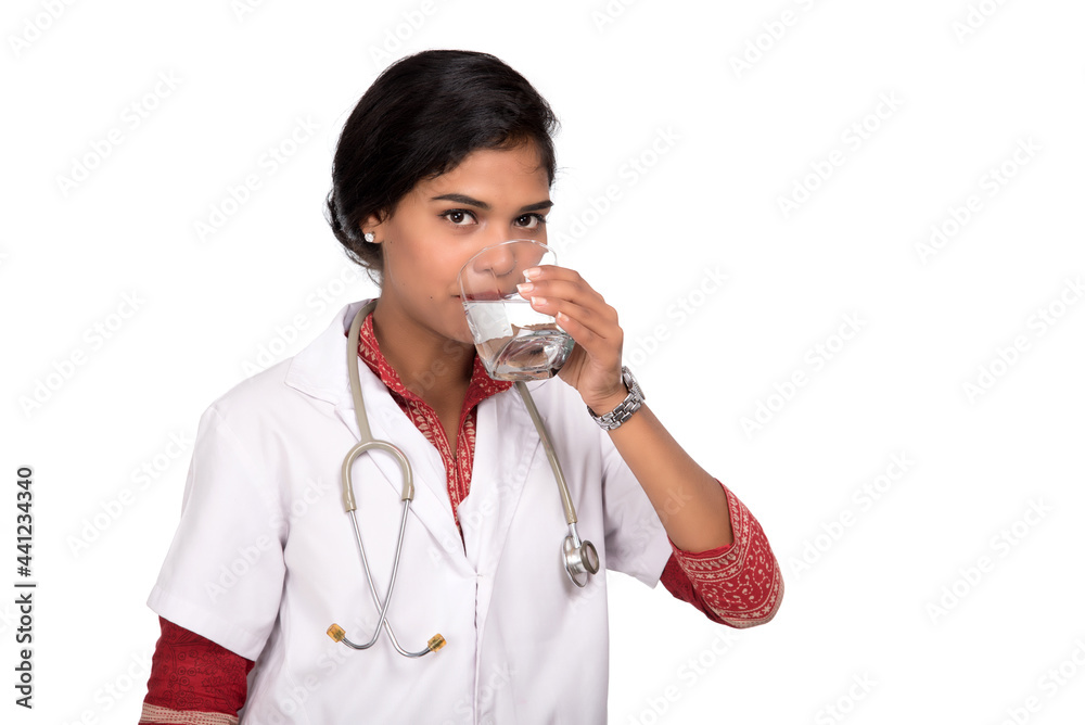 Healthy eating or lifestyle concept: young female doctor drink a glass of fresh water Healthy eating or lifestyle concept: young female doctor drink a glass of fresh water