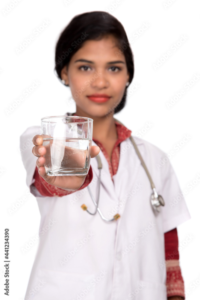 Healthy eating or lifestyle concept: Smiling female doctor holding a glass of clear fresh water Healthy eating or lifestyle concept: Smiling female doctor holding a glass of clear fresh water