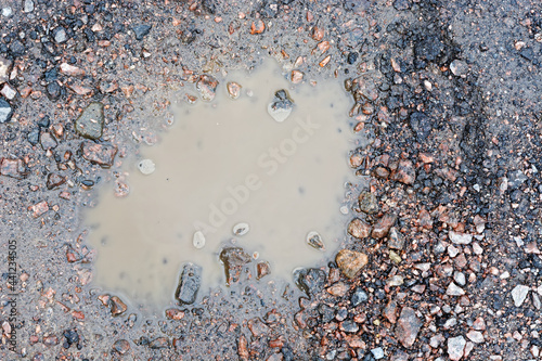 Konstfotografi Top view of a small puddle of muddy water on a rocky country road