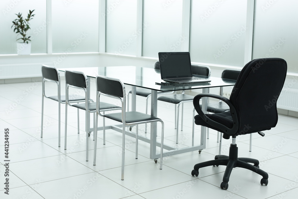 Laptop on glass table in spacious office space Laptop on glass table in spacious office space