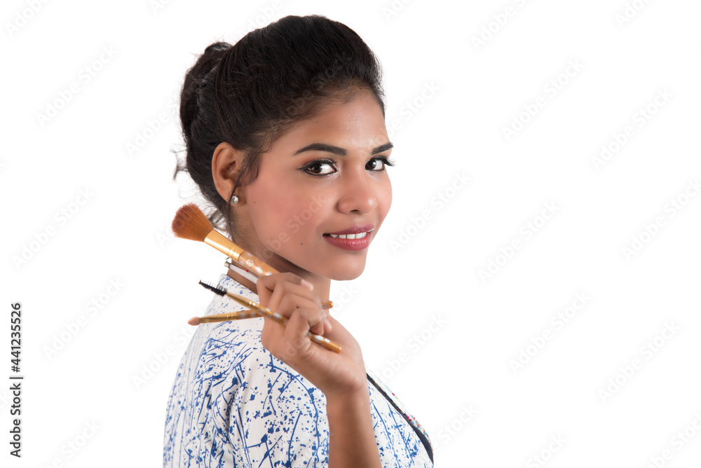 Beautiful young girl enjoying with makeup brushes isolated on white Beautiful young girl enjoying with makeup brushes isolated on white