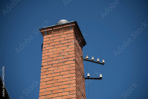 Old brick chimney with porcelain power cable isolations in Stockholm photo