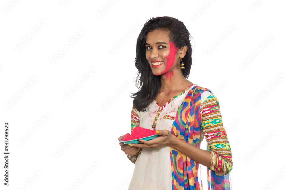 Beautiful young girl holding powdered color in plate on the occasion of Holi festival. Beautiful young girl holding powdered color in plate on the occasion of Holi festival.