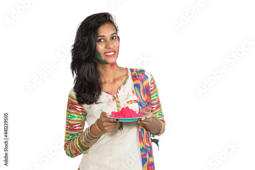 Beautiful young girl holding powdered color in plate on the occasion of Holi festival.