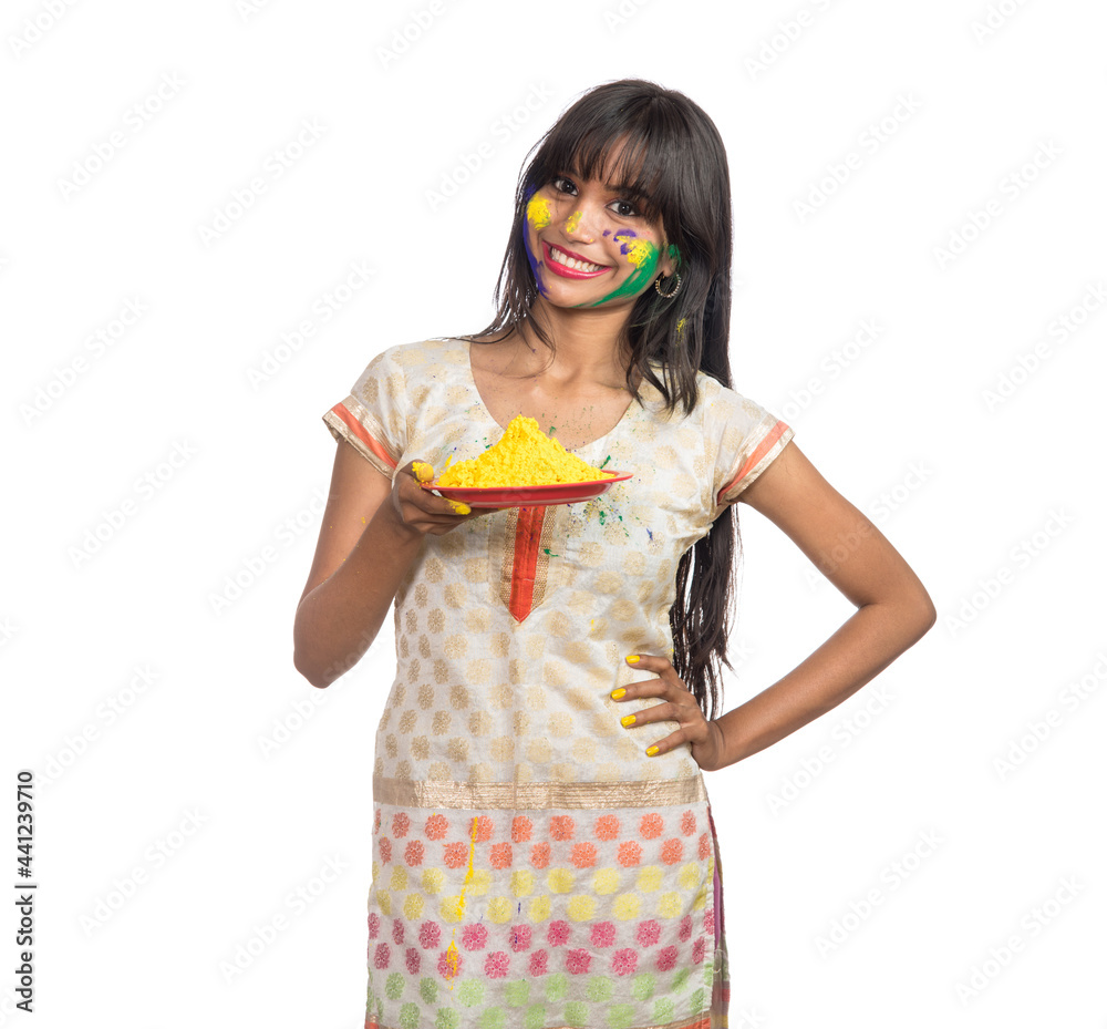 Beautiful young girl holding powdered color in plate on the occasion of Holi festival. Beautiful young girl holding powdered color in plate on the occasion of Holi festival.
