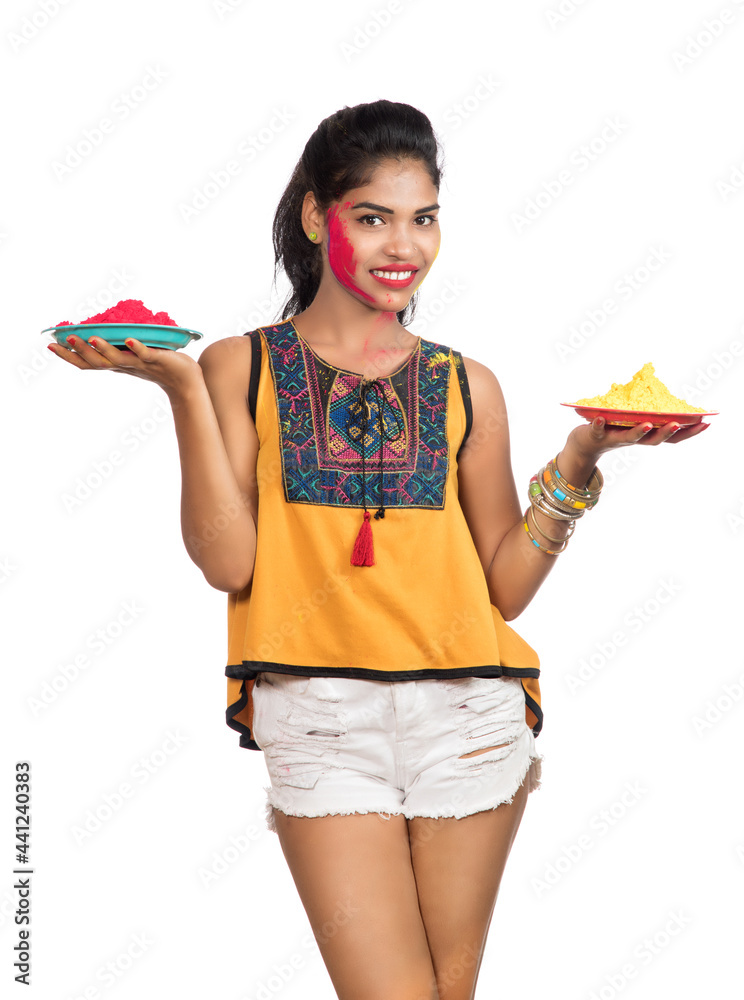 Beautiful young girl holding powdered color in plate on the occasion of Holi festival. Beautiful young girl holding powdered color in plate on the occasion of Holi festival.