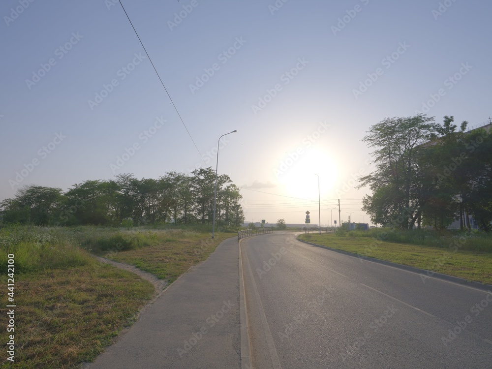 Fototapeta premium sun and reflecting asphalt road, sun landing to the road