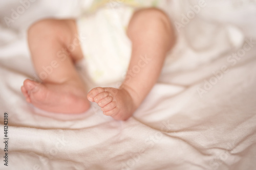 Baby legs on white sheet, newborn baby 1 month, care and love with copy space. High quality photo