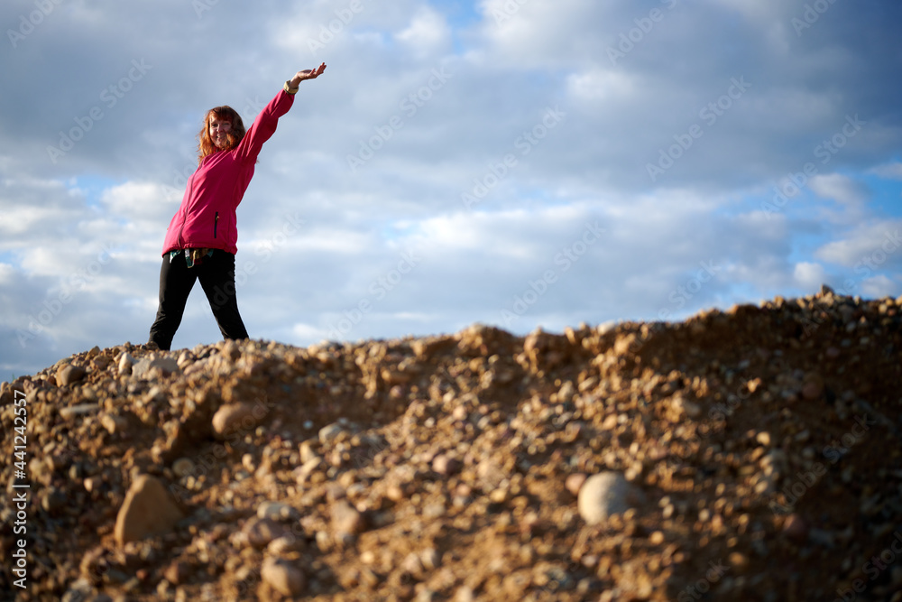 Photo woman on a sandy landscape with a raised hand. Portrait on the background of the sky Photo woman on a sandy landscape with a raised hand. Portrait on the background of the sky