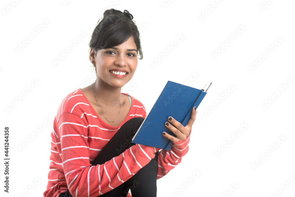 Pretty young girl holding book and posing on white background Pretty young girl holding book and posing on white background