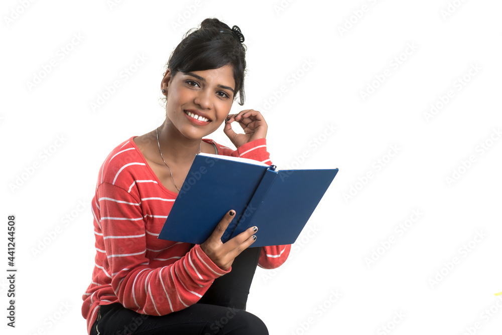 Pretty young girl holding book and posing on white background Pretty young girl holding book and posing on white background