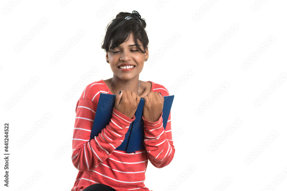 Pretty young girl holding book and posing on white background Pretty young girl holding book and posing on white background