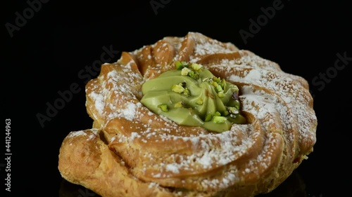 Close up delicious italian desserts with pistachio cream called zeppole of St. Joseph on black background, zoom in. Zeppole is an apulian traditional pastries for celebration of Fathers day photo