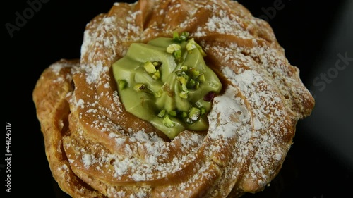 Close up delicious italian desserts with pistachio cream called zeppole of St. Joseph on black background, top view, zoom in. Zeppole is an apulian traditional pastries for celebration of Fathers day photo