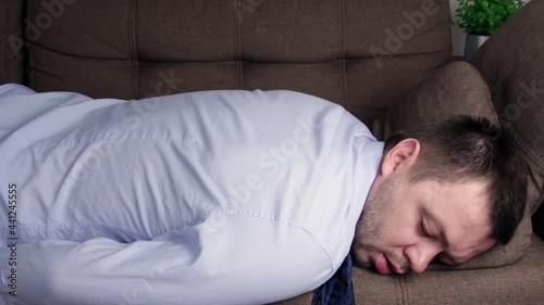 Tired business man back from work falls down asleep on the couch,overwhelmed businessman in shirt throws himself on the sofa and start sleeping,hard day concept