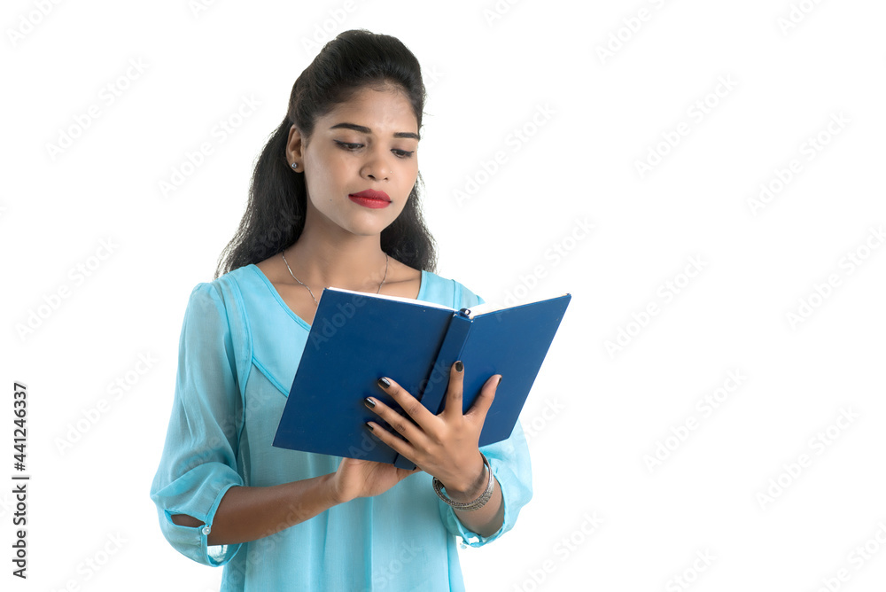 Pretty young girl holding book and posing on white background Pretty young girl holding book and posing on white background