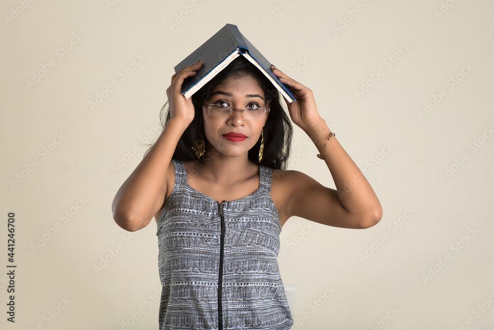 Pretty young girl holding and posing with book