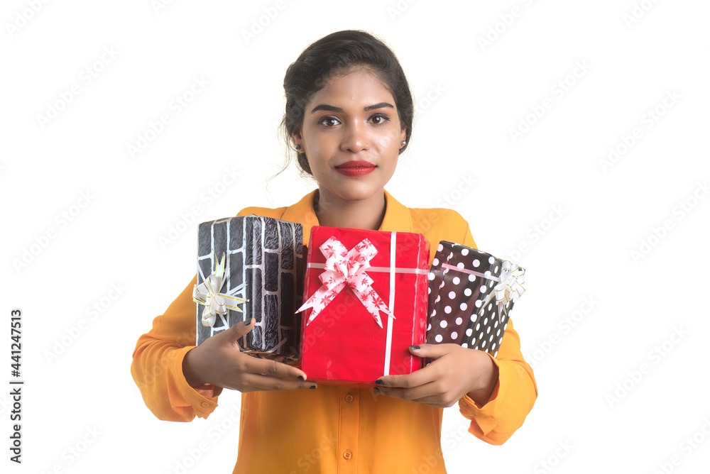 Portrait of young happy smiling Indian Girl holding gift boxes on a white background. Portrait of young happy smiling Indian Girl holding gift boxes on a white background.