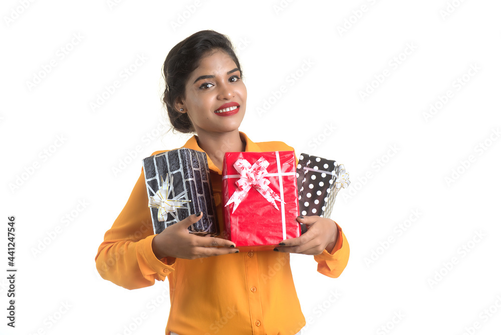 Portrait of young happy smiling Indian Girl holding gift boxes on a white background. Portrait of young happy smiling Indian Girl holding gift boxes on a white background.