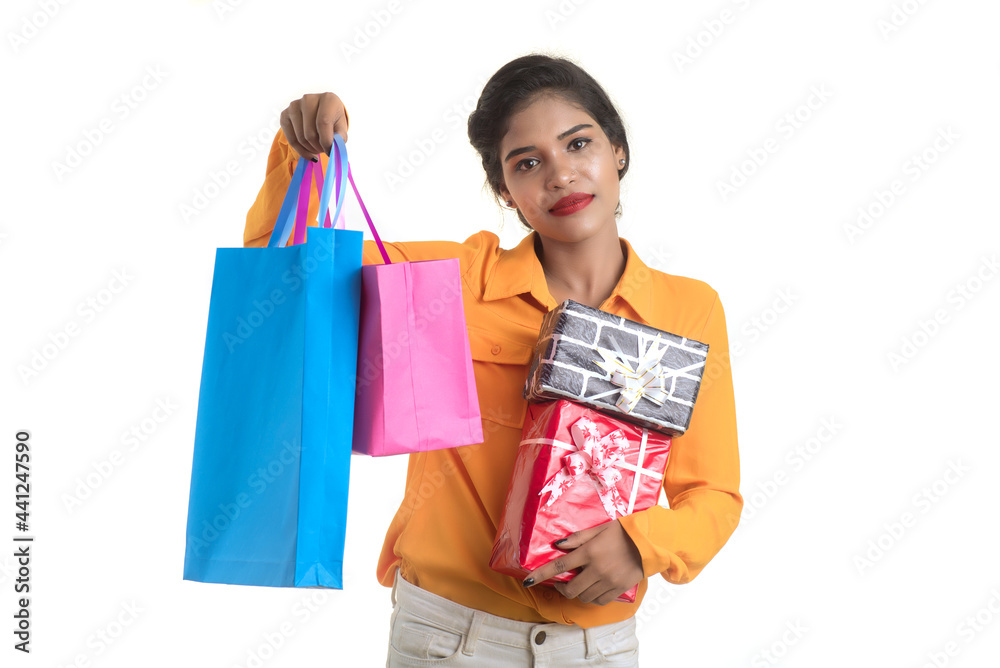 Beautiful woman carrying many shopping bags and gift Box on a white background. Beautiful woman carrying many shopping bags and gift Box on a white background.
