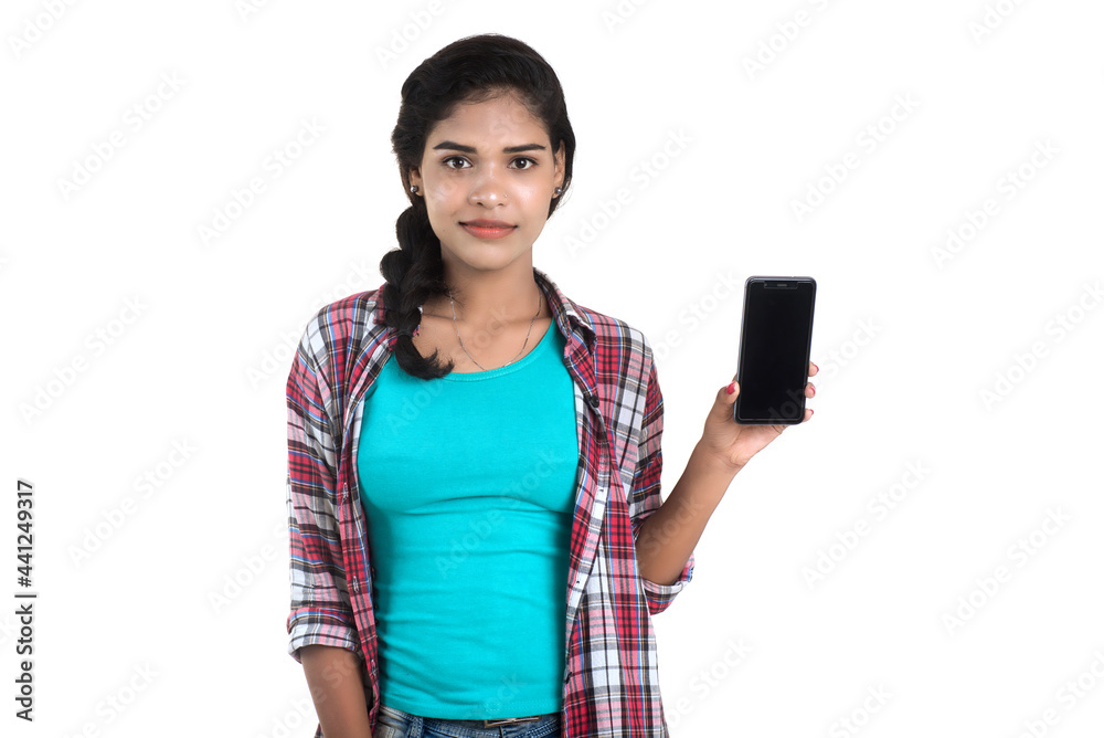 Young Indian girl using a mobile phone or smartphone isolated on a white background Young Indian girl using a mobile phone or smartphone isolated on a white background
