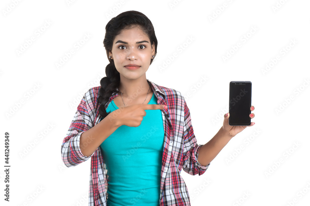 Young Indian girl using a mobile phone or smartphone isolated on a white background Young Indian girl using a mobile phone or smartphone isolated on a white background