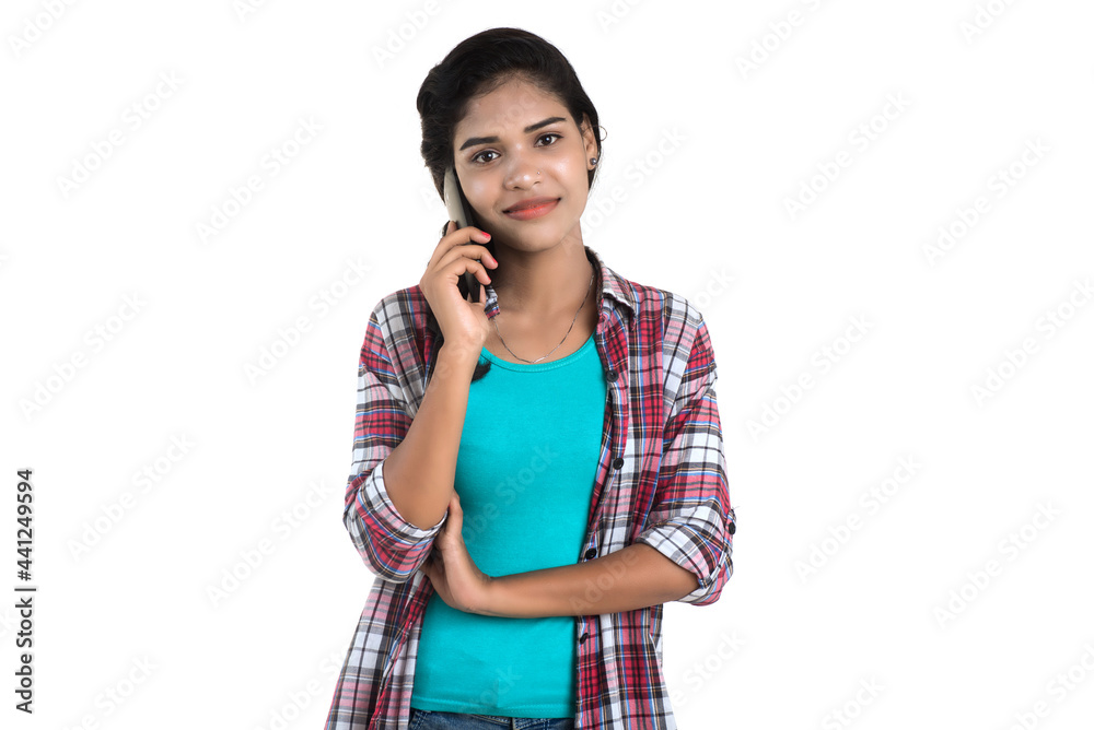 Young Indian girl using a mobile phone or smartphone isolated on a white background