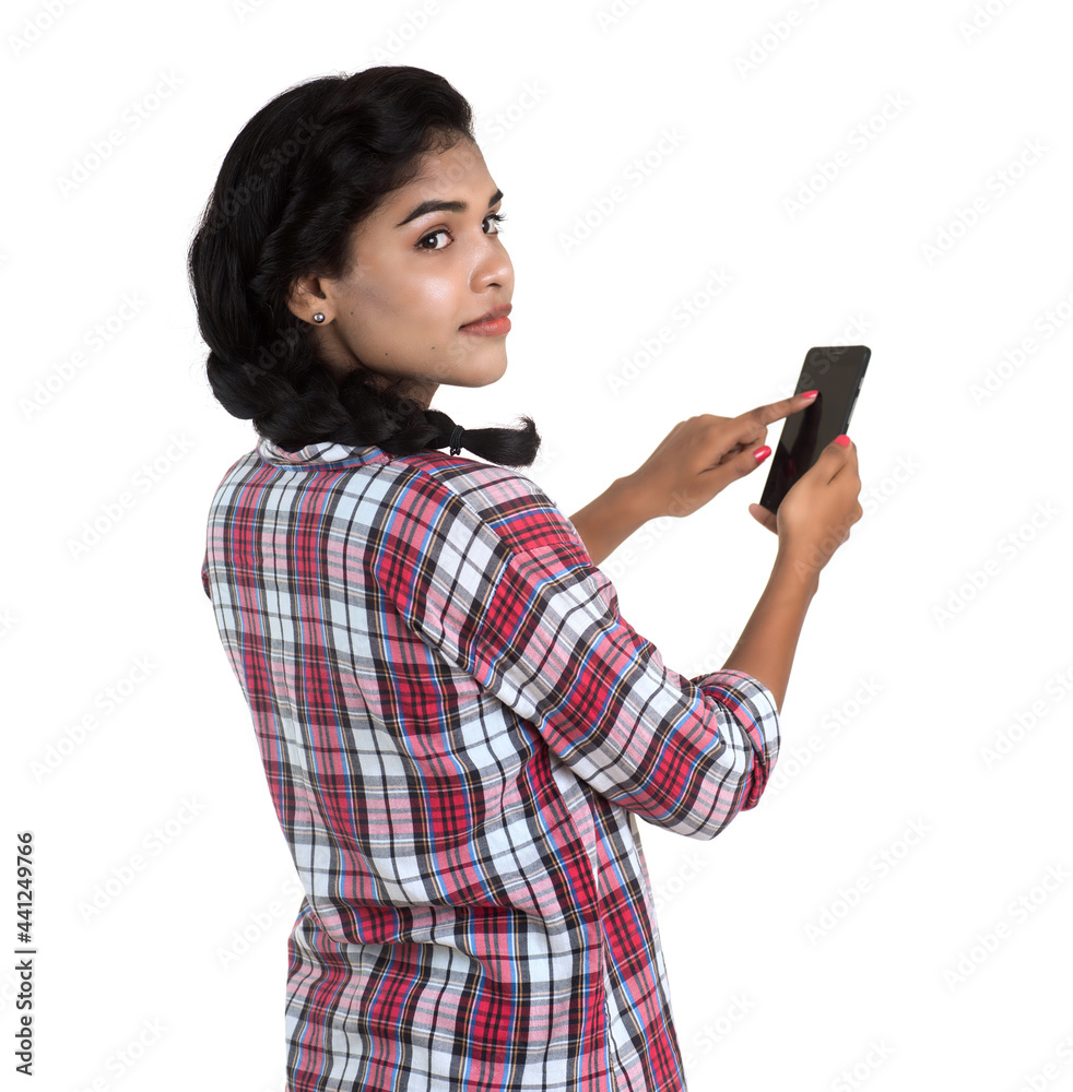 Young Indian girl using a mobile phone or smartphone isolated on a white background Young Indian girl using a mobile phone or smartphone isolated on a white background