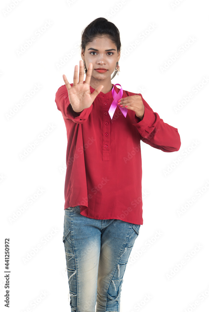 Healthcare and medicine concept - young woman hands holding pink breast cancer awareness ribbon Healthcare and medicine concept - young woman hands holding pink breast cancer awareness ribbon
