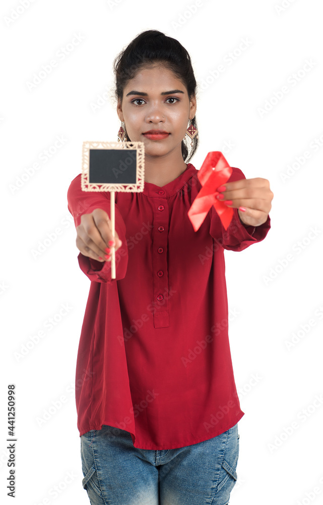 Young woman showing red ribbon HIV, AIDS awareness ribbon, healthcare and medicine concept Young woman showing red ribbon HIV, AIDS awareness ribbon, healthcare and medicine concept