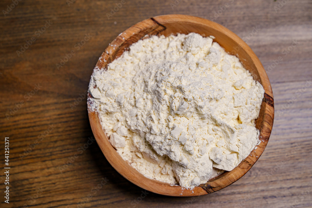 flour in a wooden dish on the kitchen table. flour in a wooden dish on the kitchen table.