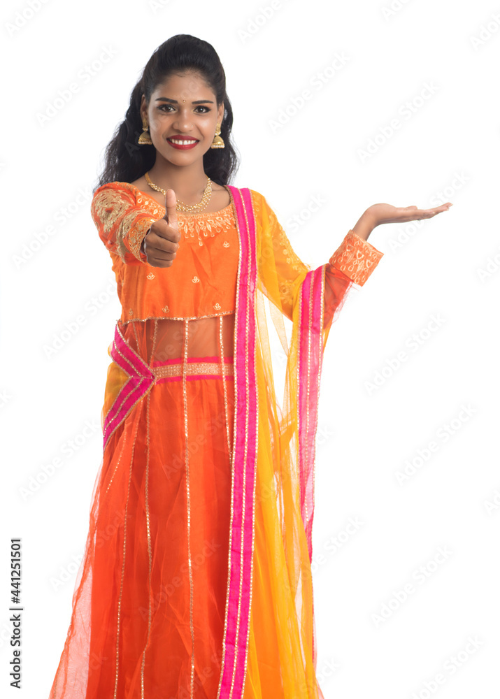 Portrait of cheerful Indian traditional young woman presenting something on hand, showing copy space on her palm on a white background Portrait of cheerful Indian traditional young woman presenting something on hand, showing copy space on her palm on a white background