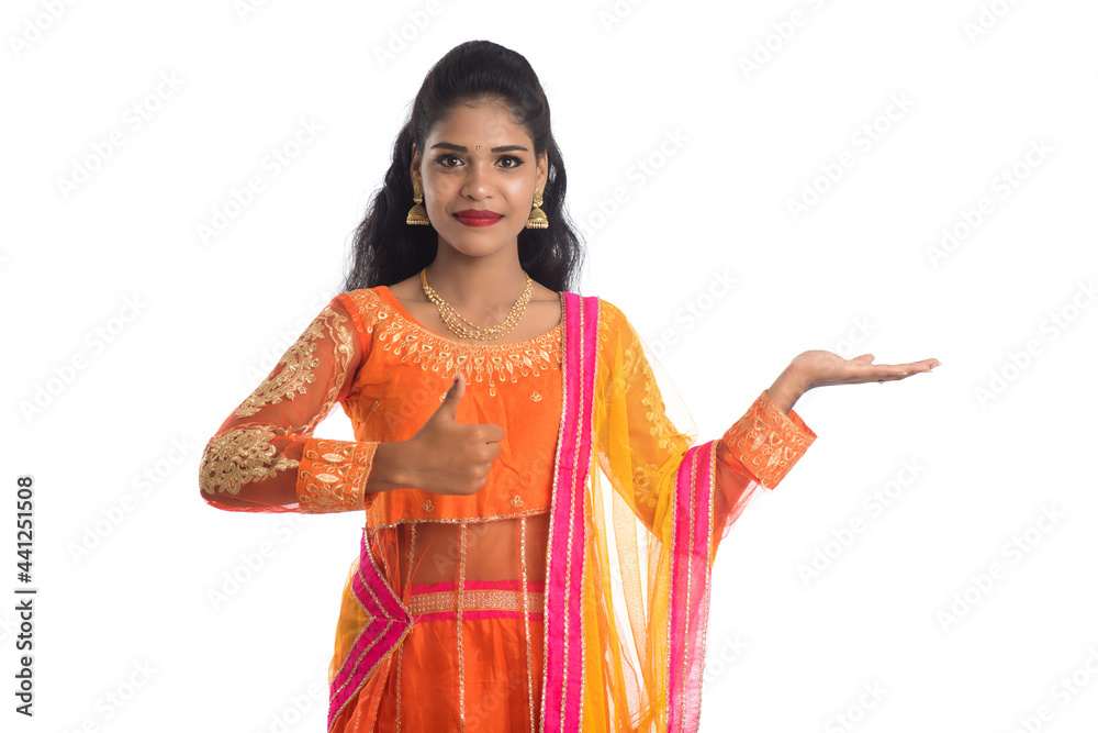 Portrait of cheerful Indian traditional young woman presenting something on hand, showing copy space on her palm on a white background
