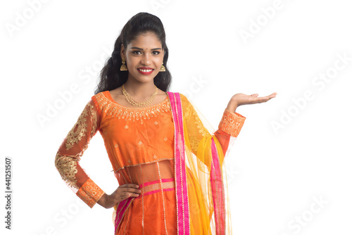 Portrait of cheerful Indian traditional young woman presenting something on hand, showing copy space on her palm on a white background