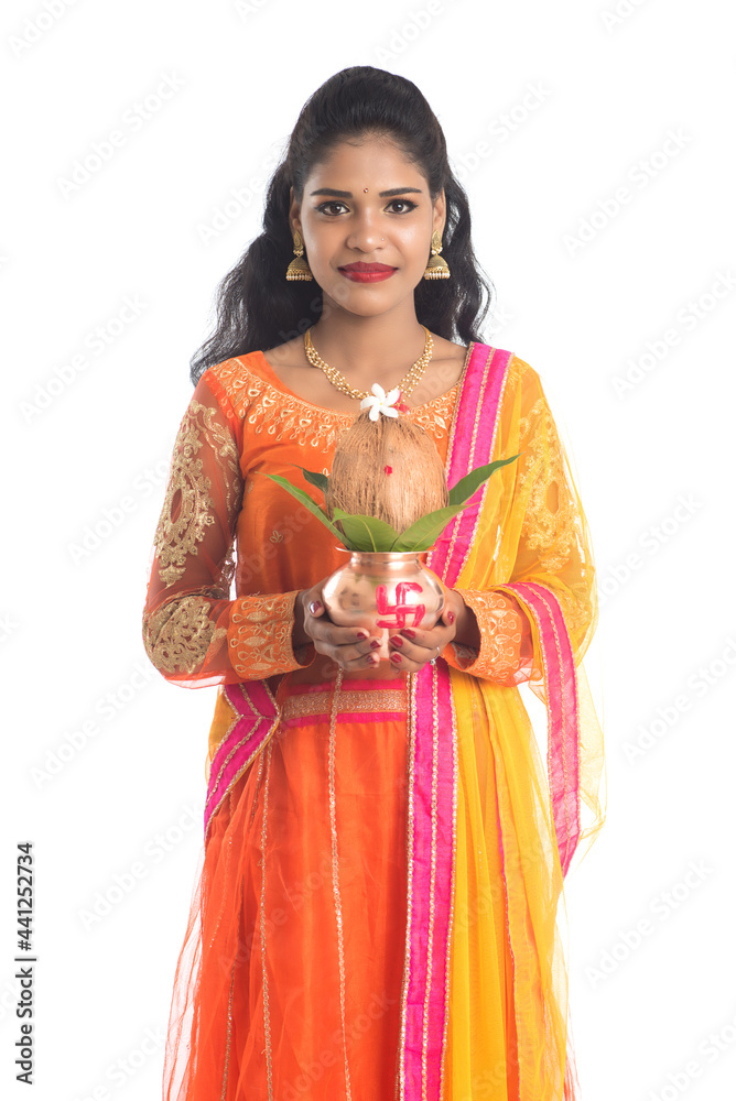 Indian Woman holding a traditional copper kalash, Indian Festival, copper kalash with coconut and mango leaf with floral decoration, essential in hindu puja.