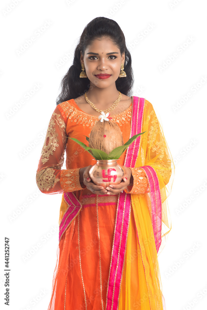 Indian Woman holding a traditional copper kalash, Indian Festival, copper kalash with coconut and mango leaf with floral decoration, essential in hindu puja.