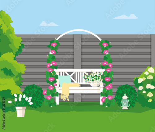 A garden bench under an arch with weaving flowers.