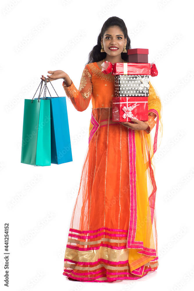Beautiful woman carrying many shopping bags and gift Box on a white background. Beautiful woman carrying many shopping bags and gift Box on a white background.