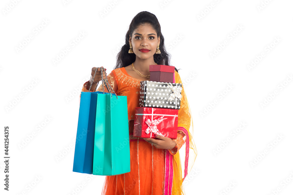 Beautiful woman carrying many shopping bags and gift Box on a white background. Beautiful woman carrying many shopping bags and gift Box on a white background.