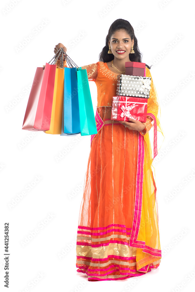 Beautiful woman carrying many shopping bags and gift Box on a white background. Beautiful woman carrying many shopping bags and gift Box on a white background.