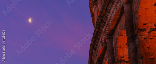 Close-up view of Coliseum and the moon at the sunrise, Rome, Italy